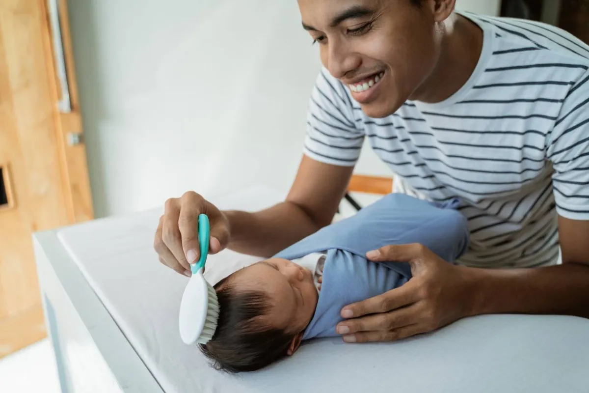 صورة لأب يمشط شعر طفله