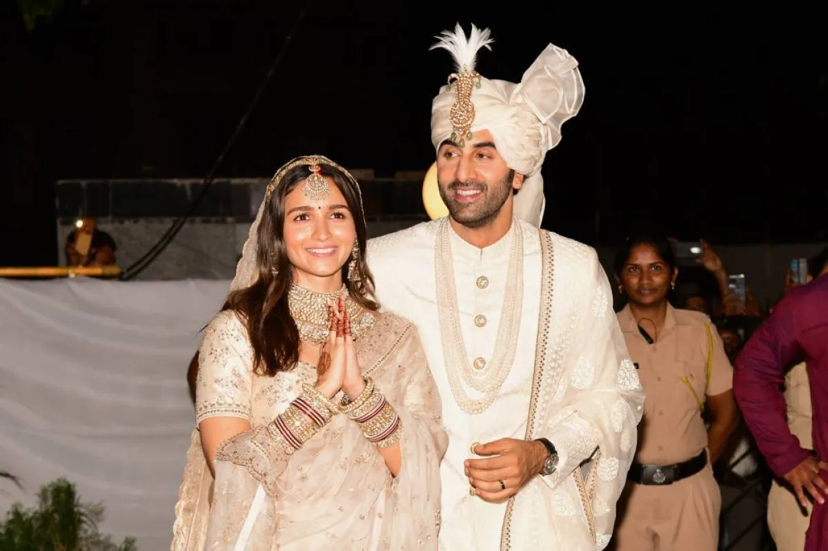 Bollywood actors Ranbir Kapoor (R) and Alia Bhatt gesture as they pose for pictures during their wedding ceremony in Mumbai on April 14, 2022. SUJIT JAISWAL / AFP