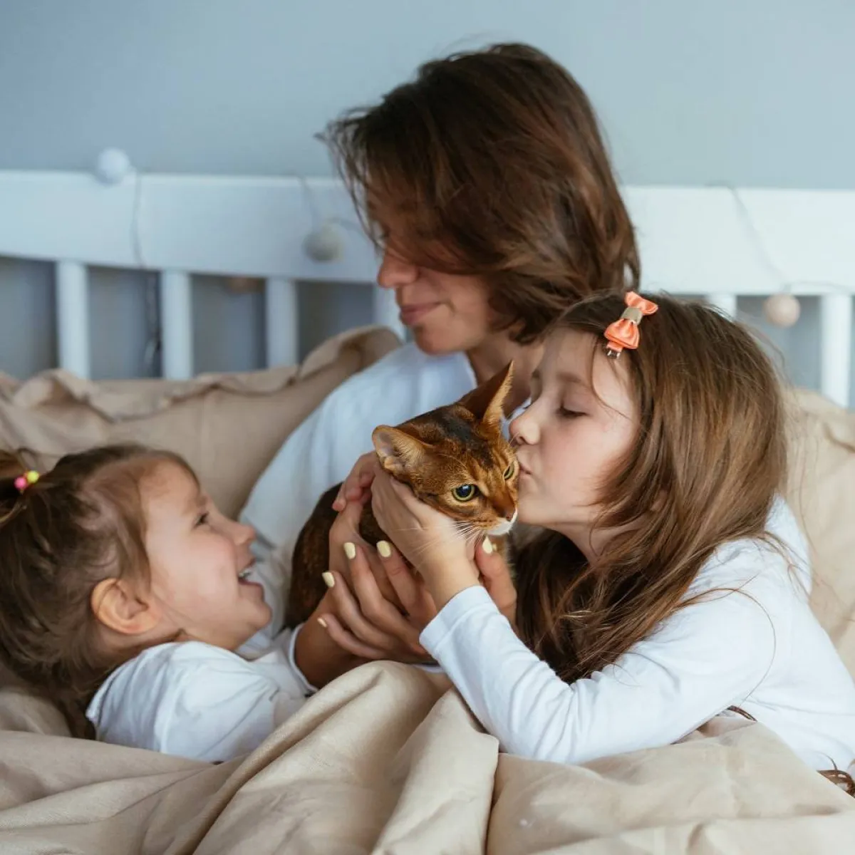 صورة لام تلعب مع أولادها والقطة