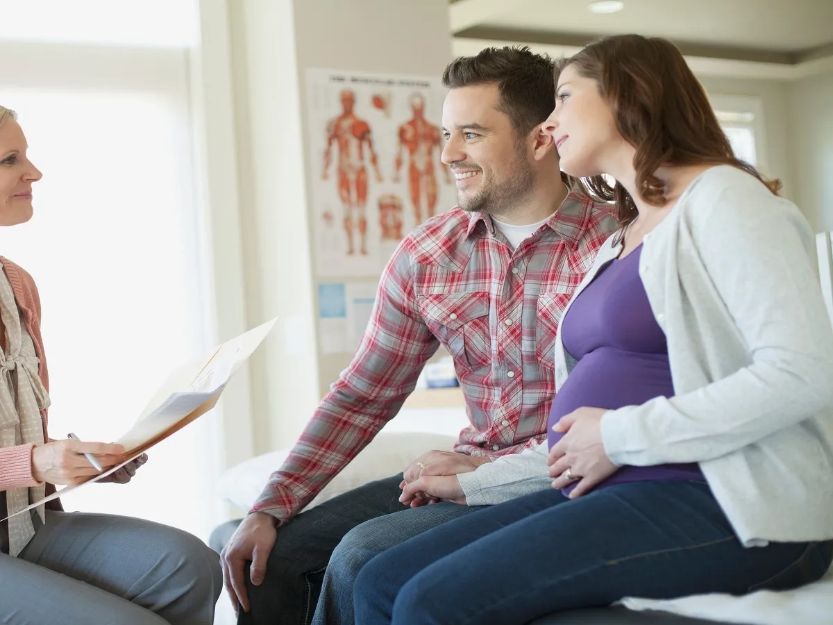 صورة لأب وأم يتحدثان مع طبيبة