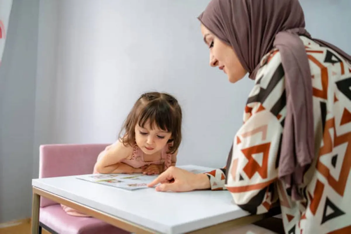 صورة لأم تساعد طفلتها في حل الدروس
