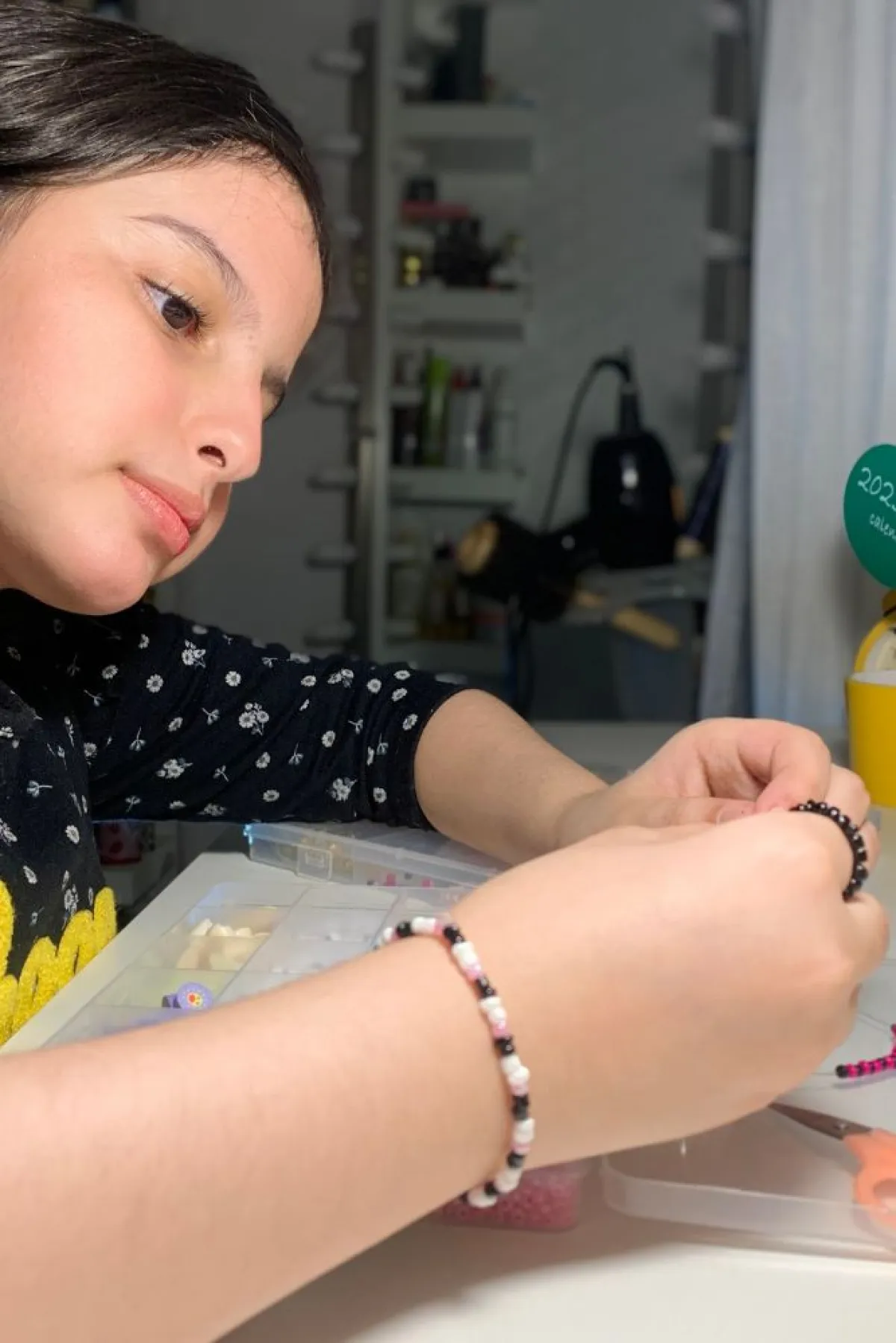 تظهر الصورة الطفلة وهي تصنع الخرز