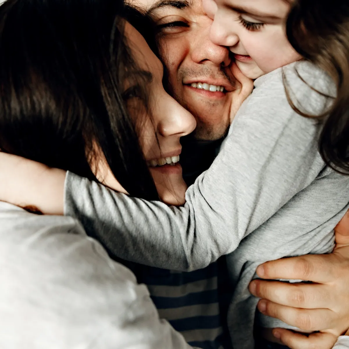 صورة لأب وأم يحتضنان طفلتهما