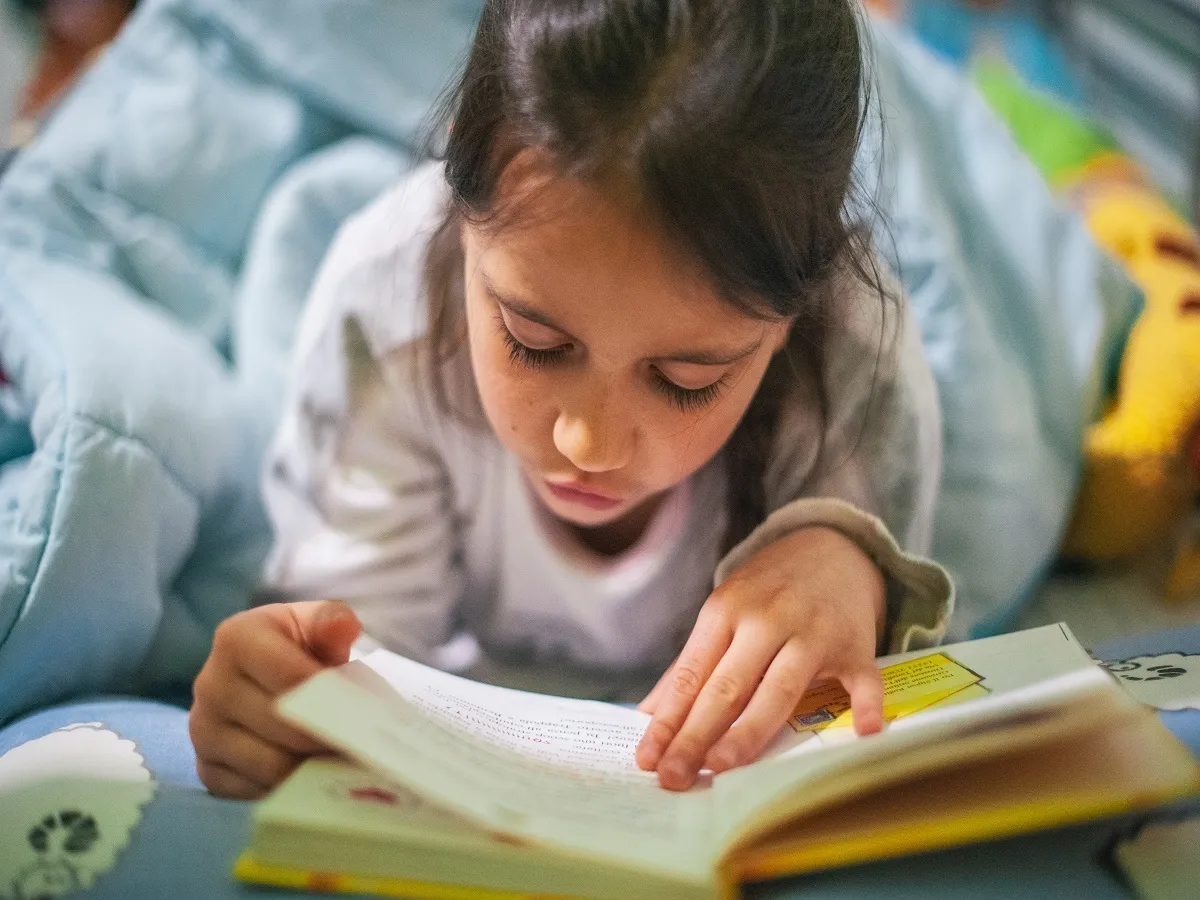 صورة لطفلة تقرأ كتاباً