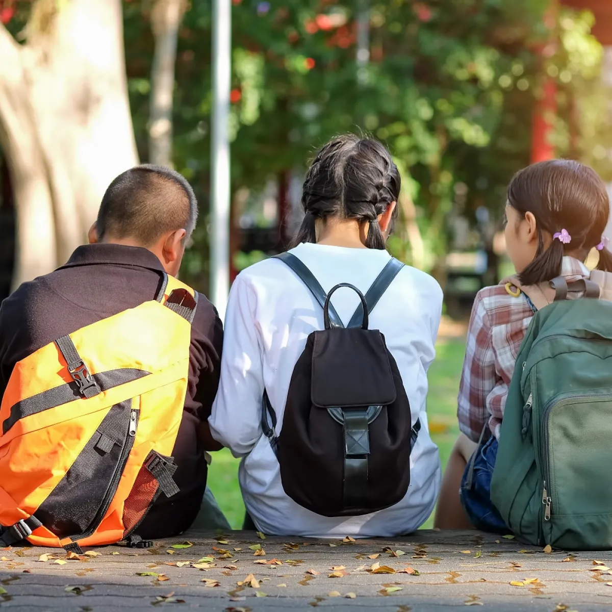 صورة لثلاثة أطفال يحملون الحقائب