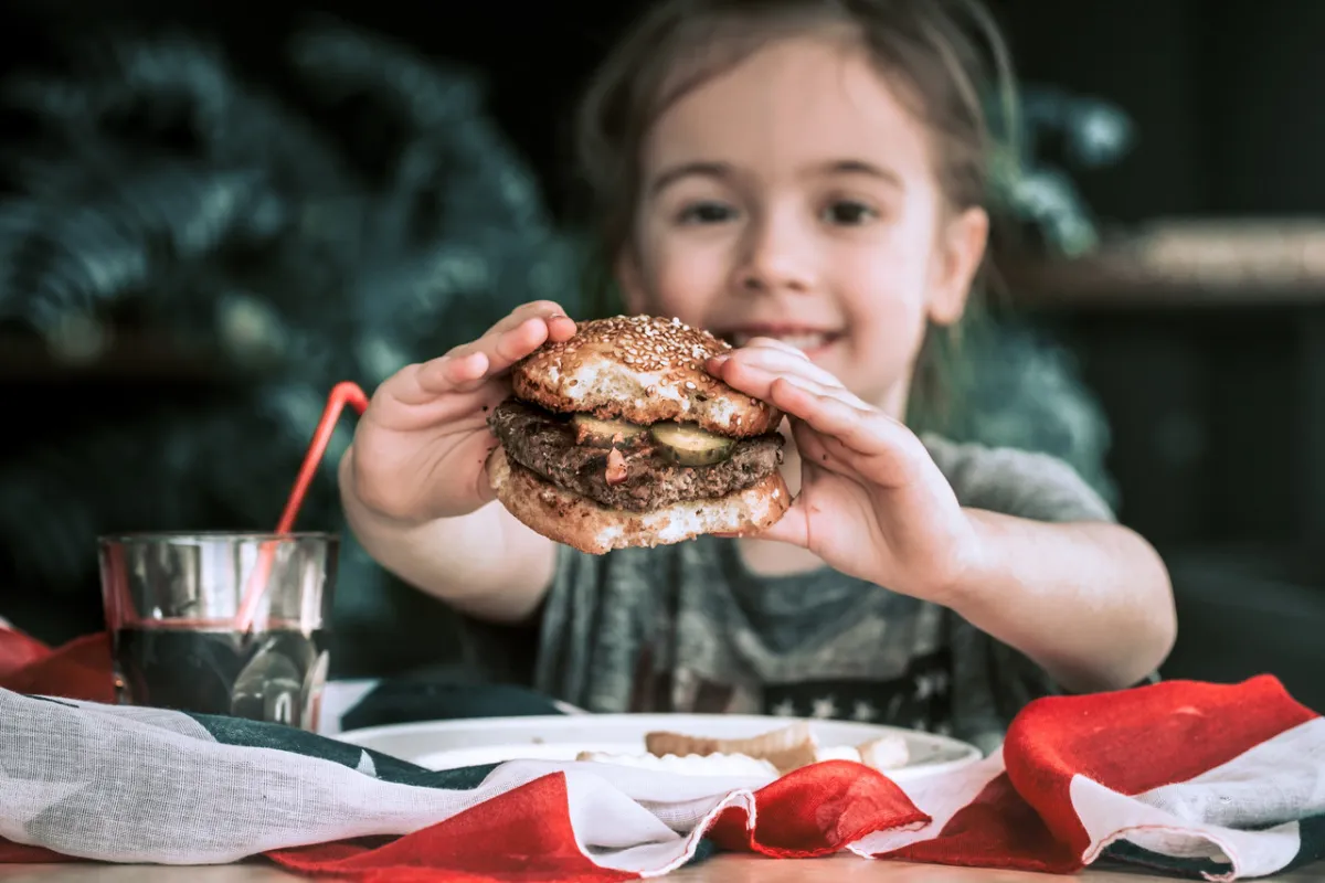 صورة لطفلة تأكل اللحوم