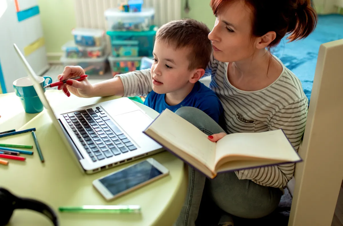 صورة لأم تساعد طفلها في الدراسة