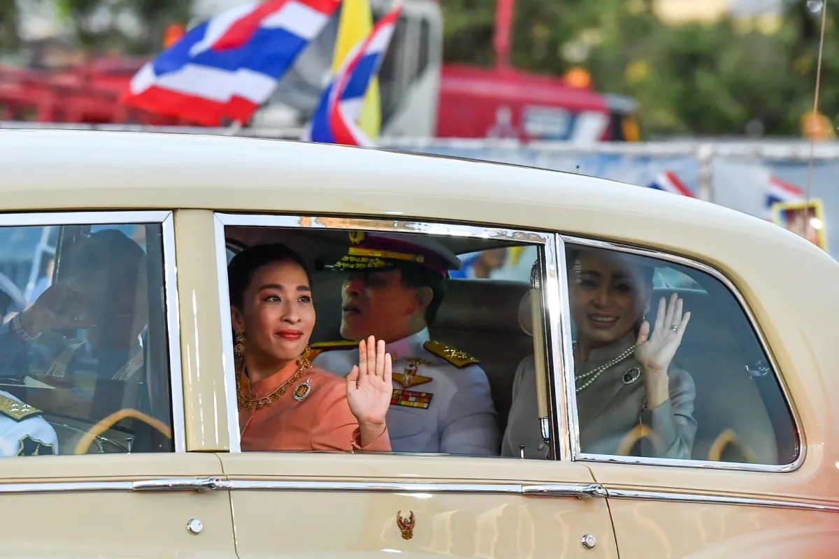 In this file photo taken on November 1, 2020 Thai Princess Bajrakitiyabha Mahidol (centre L) waves from a car, sitting next to Thailand's King Maha Vajiralongkorn (C) and Queen Suthida (R), on arrival at the Grand Palace in Bangkok. Lillian SUWANRUMPHA / AFP