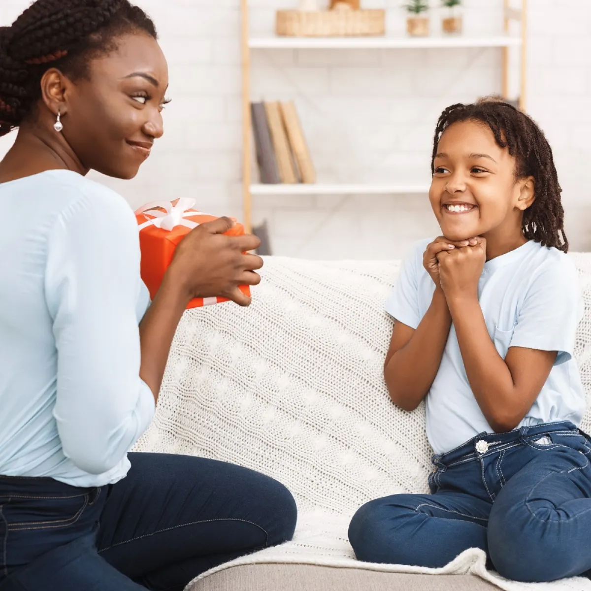 صورة لأم تقدم هدية لطفلتها