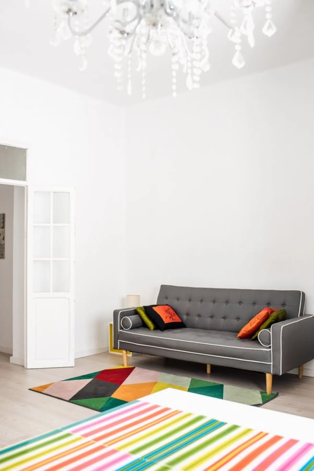 أريكة مزودة بقوائم ظاهرة، ومبطنة بنسيج ذي لون محايد