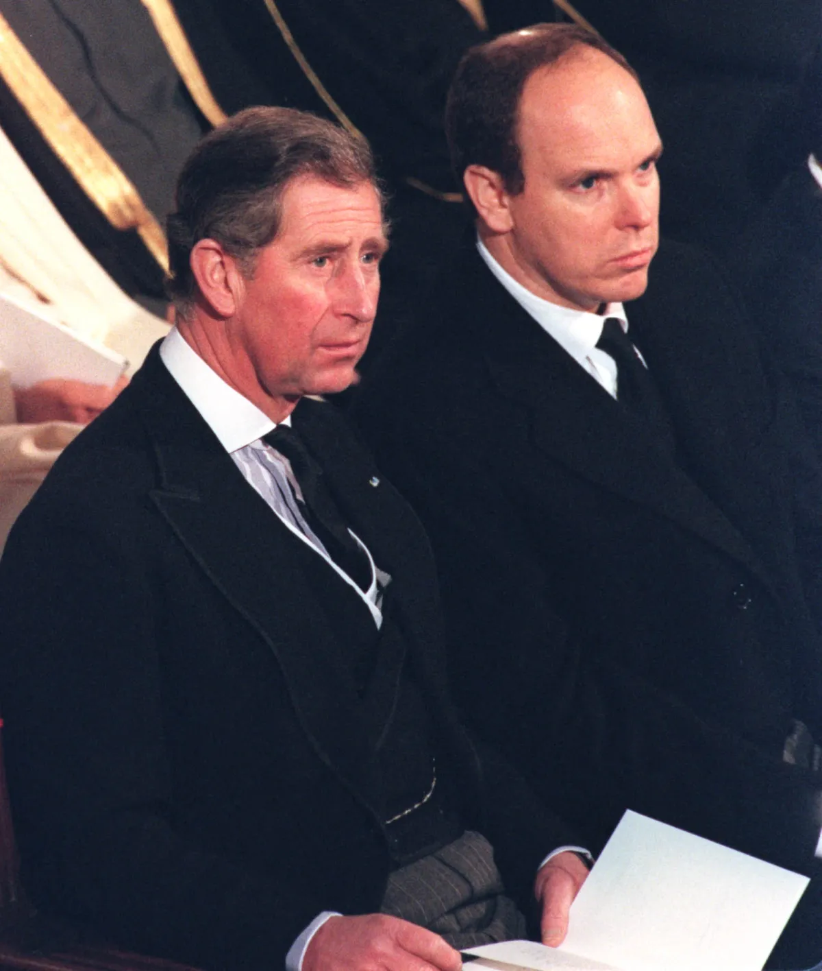 Prince Charles, the Prince of Wales, left, is seated next to Prince Albert of Monaco 13 January 2000 during a funeral mass for the mother of King Juan Carlos of Spain, Maria de las Mercedes de Borbon y Orleans, the Countess of Barcelona, who died January 2 at the age of 89. PAUL WHITE / POOL / AFP