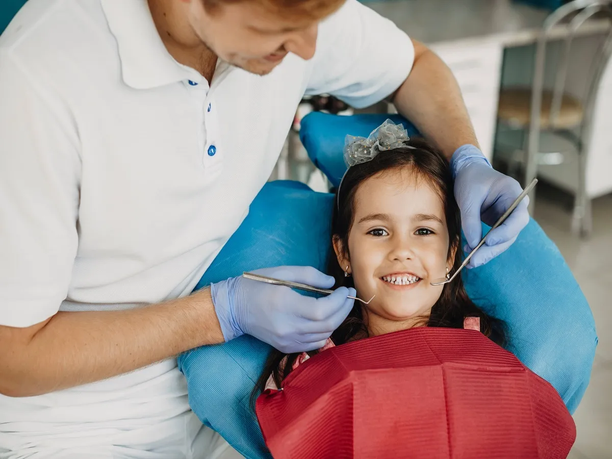 صوة لطبيب يفحص أسنان طفلة
