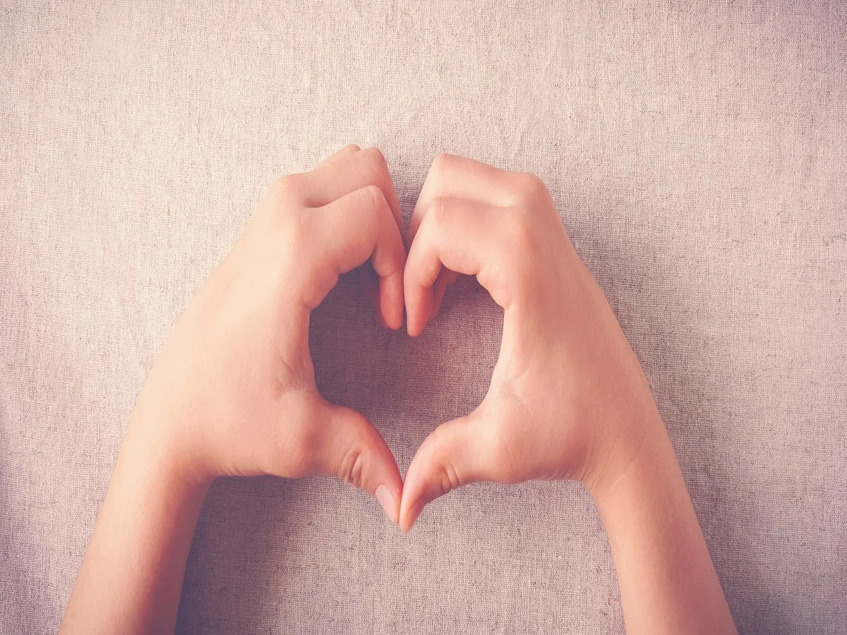 صورة لطفل يرسم قلب بيديه