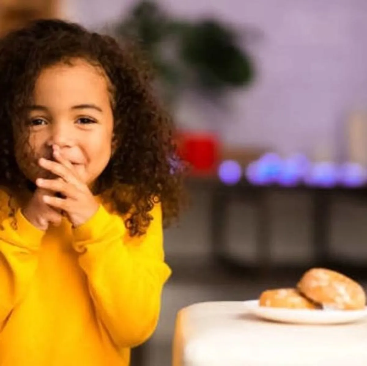  طفلة سعيدة وطبق الخبز بجانبها