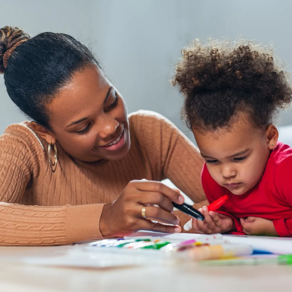 صورة لطفلة ترسم ومعها أمها