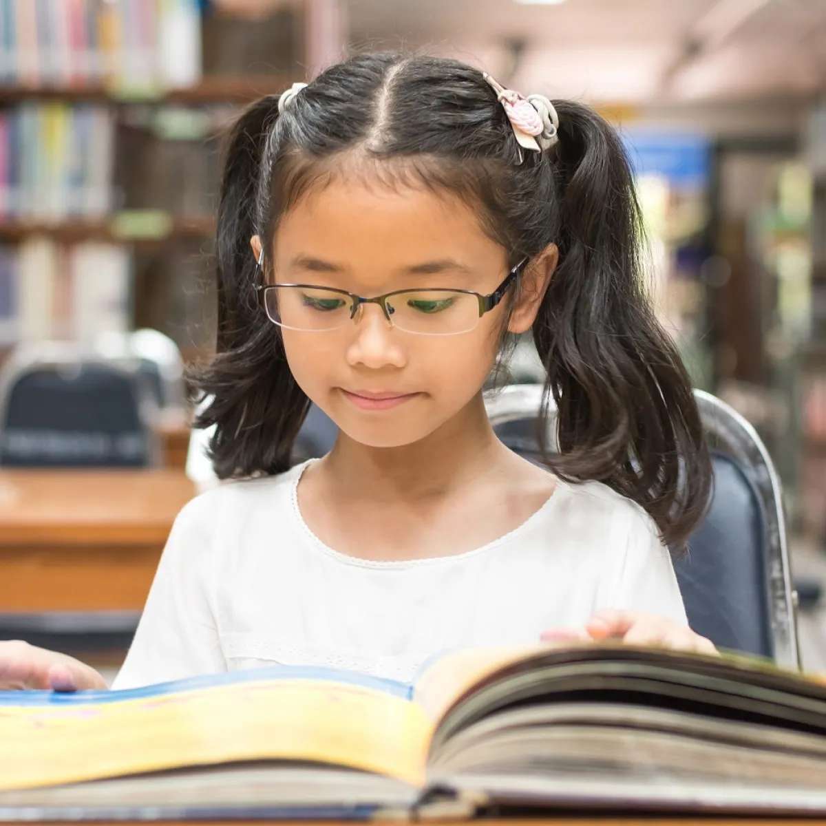 صورة لطفلة تتصفح الكتاب