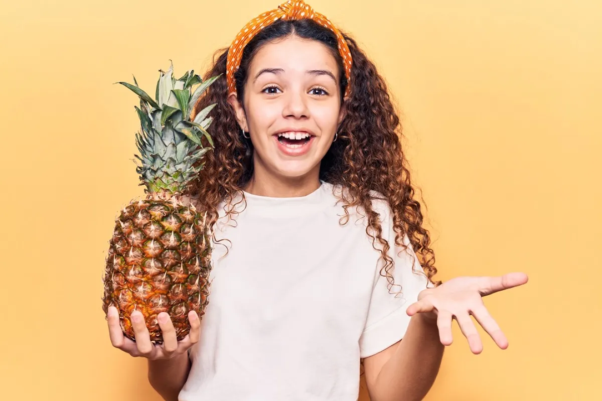 صورة لطفلة تحمل فاكهة