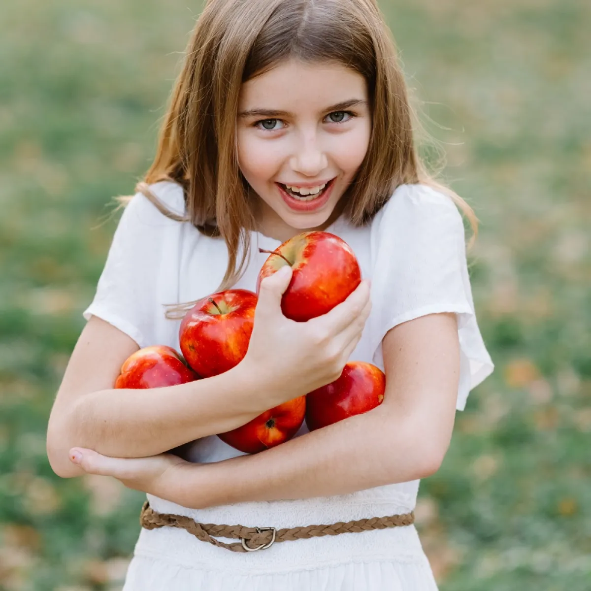 صورة لطفلة تحمل التفاح