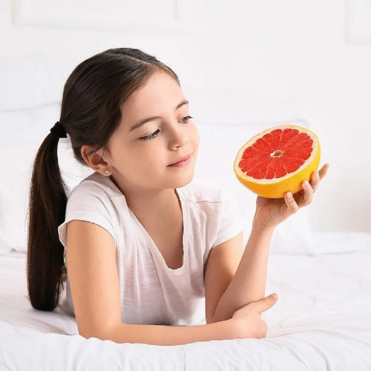 صورة لطفلة تمسك بفاكهتها المفضلة