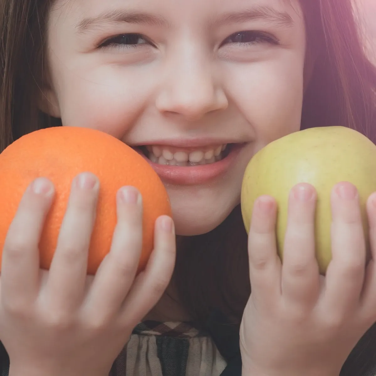 صورة لطفلة تمسك بالفاكهة