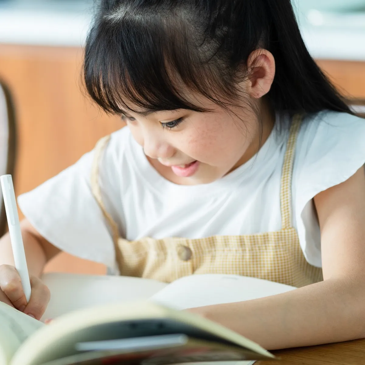 صورة لطفلة تعمل واجباتها وحدها