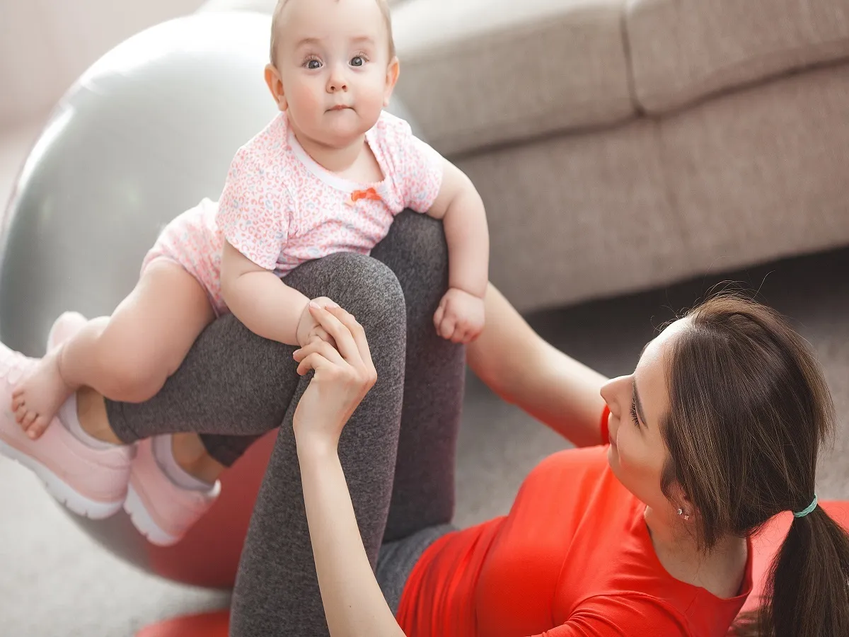صورة لامراة حامل تقوم بممارسة الرياضة مع طفلها الرضيع