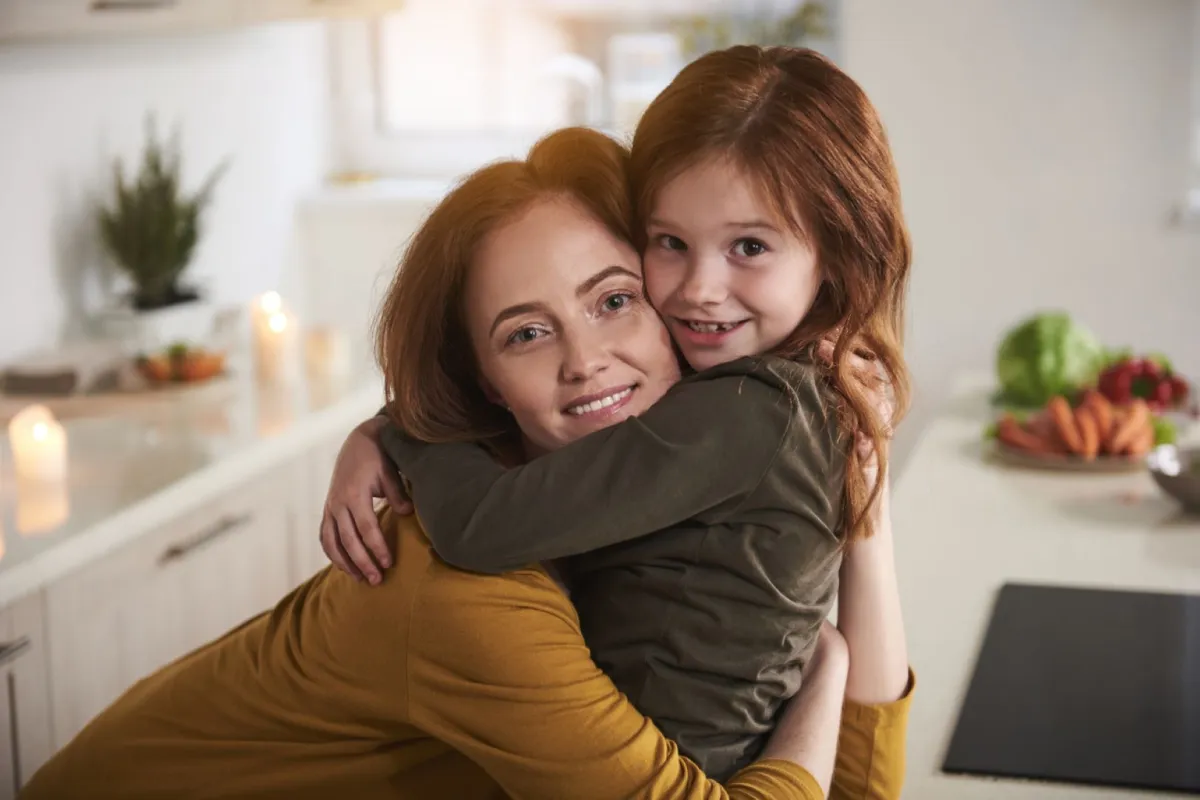 صورة أم تعانق طفلتها