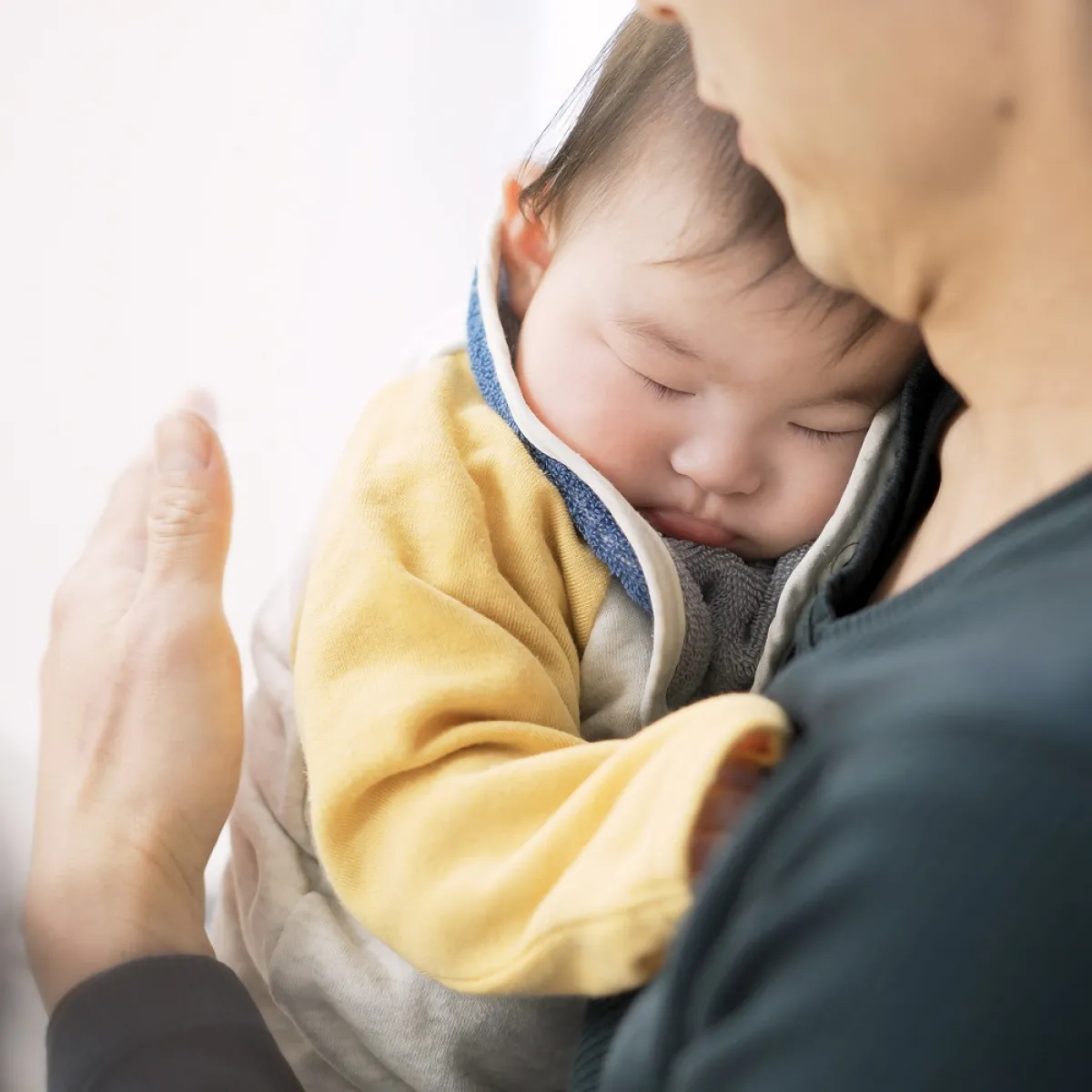 صورة لأم تقوم بتجشئة رضيعها