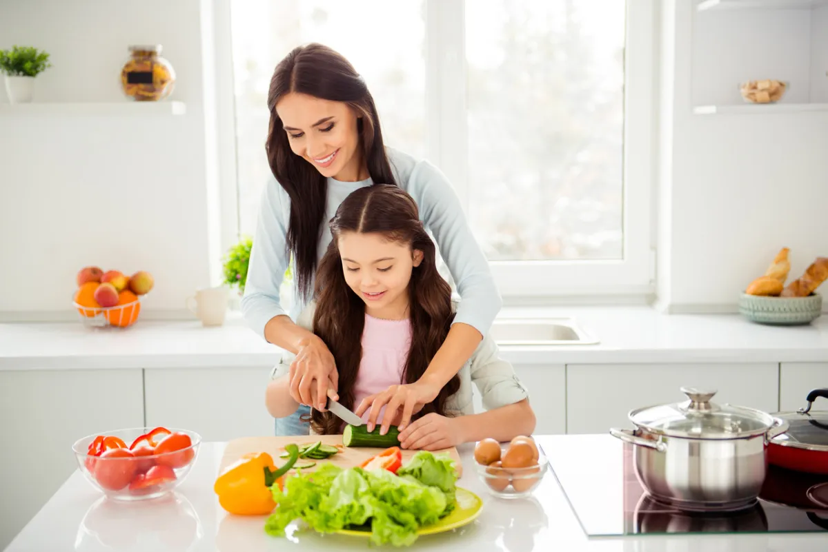 صورة طفلة تقطع الخضراوات