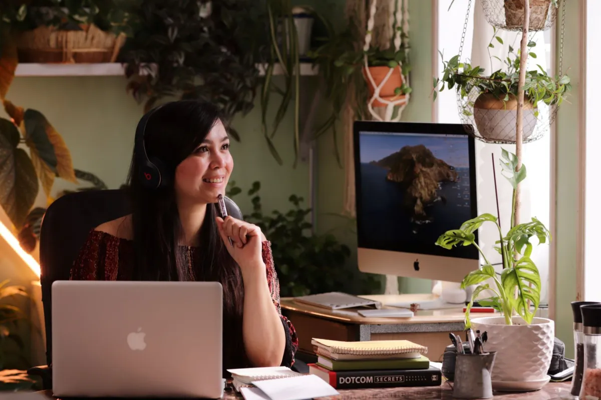 فتاة تجلس أمام الكمبيوتر المحمول