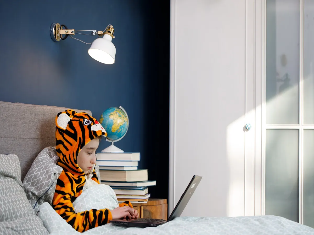 صورة لطفل يجلس على جهاز الكمبيوتر