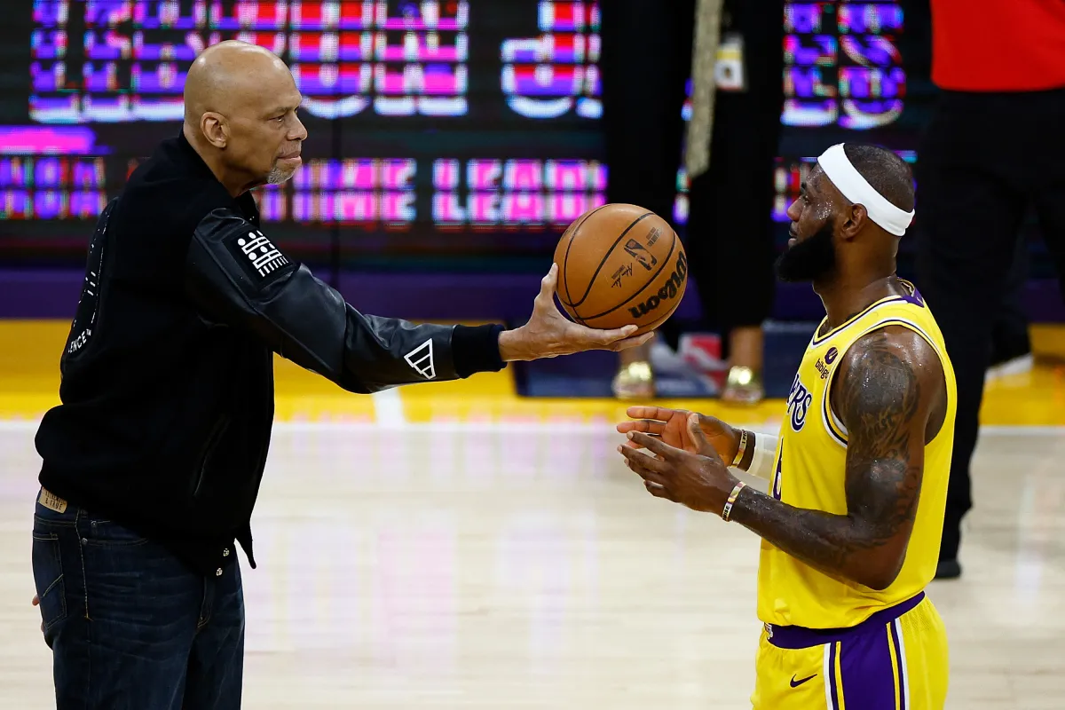 Kareem Abdul-Jabbar ceremoniously hands LeBron James #6 of the Los Angeles Lakers the ball after James passed Abdul-Jabbar to become the NBA's all-time leading scorer, at Crypto.com Arena on February 7, 2023 in Los Angeles, California. RONALD MARTINEZ / GETTY IMAGES NORTH AMERICA / Getty Images via AFP