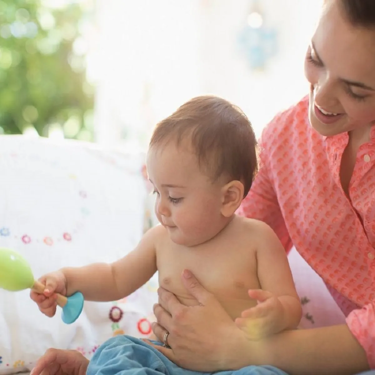 صورة لطفل يلعب وهو جالس مع أمه