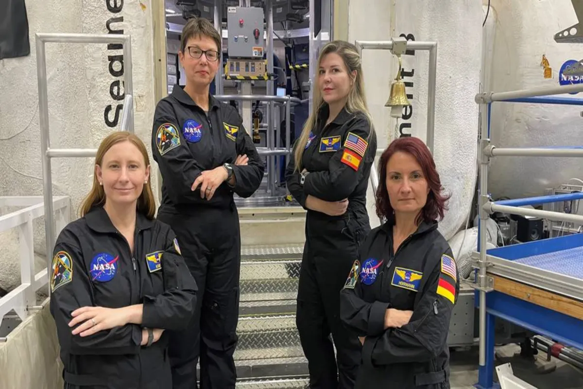 he crew for the next mission of NASA's Human Exploration Research Analog, or HERA, stand outside the HERA habitat Pictured from left to right: Katie Koube, Kimberly Knish, Vanesa Gomez Gonzalez, and Sandra Herrmann. Credits: Credit: NASA