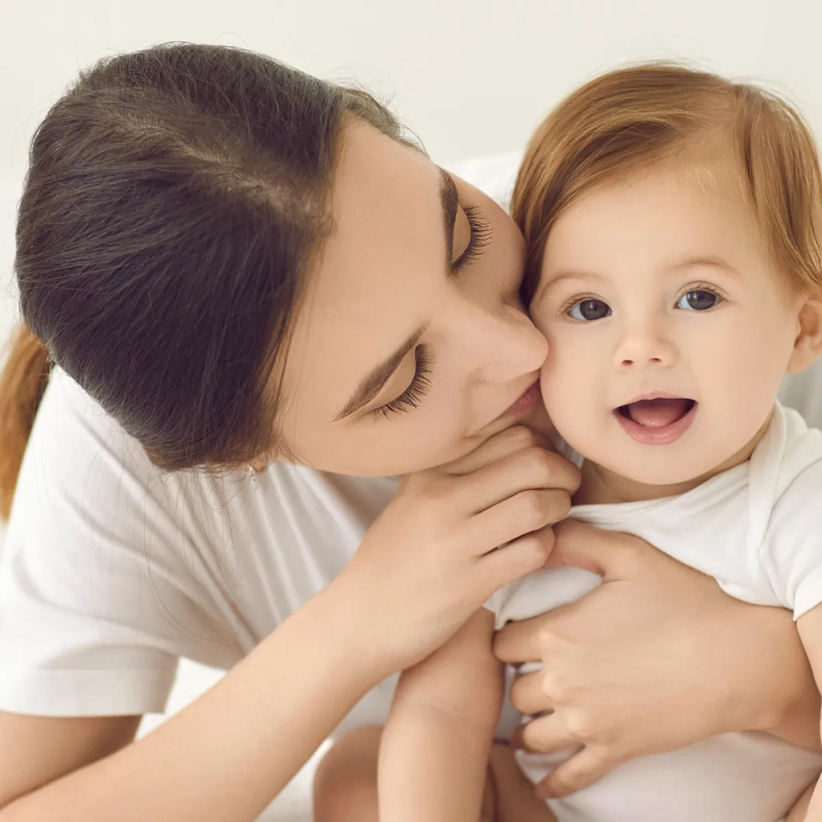 صورة لأم تقبل طفلها وتشعره بالحب