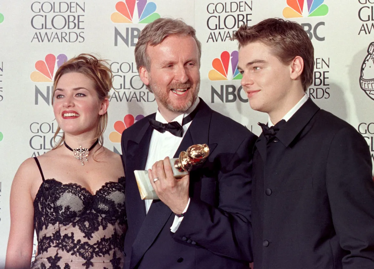  Director James Cameron(C) and actress Kate Winslet(L) and actor Leonardo DiCaprio(R) pose for photographers after Cameron won the award for Best Director for "Titanic" at the 55th Annual Golden Globe Awards at the Beverly Hilton 18 January in Beverly Hills. ". AFP PHOTO Hal GARB HAL GARB / AFP