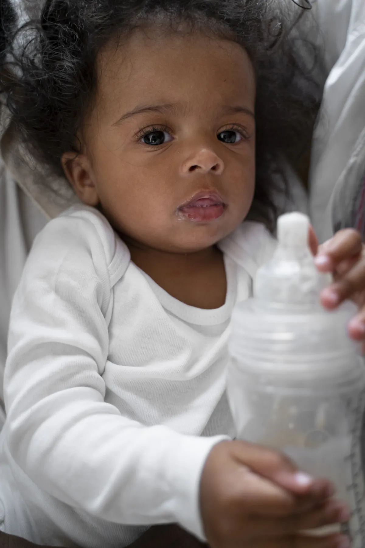 صورة طفل يلعب بزجاجة الحليب