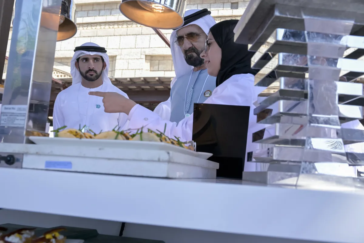 الشيخ محمد بن راشد والشيخ حمدان بن محمد يستمعان إلى قصة نجاح عائشة. الصورة من "وام"