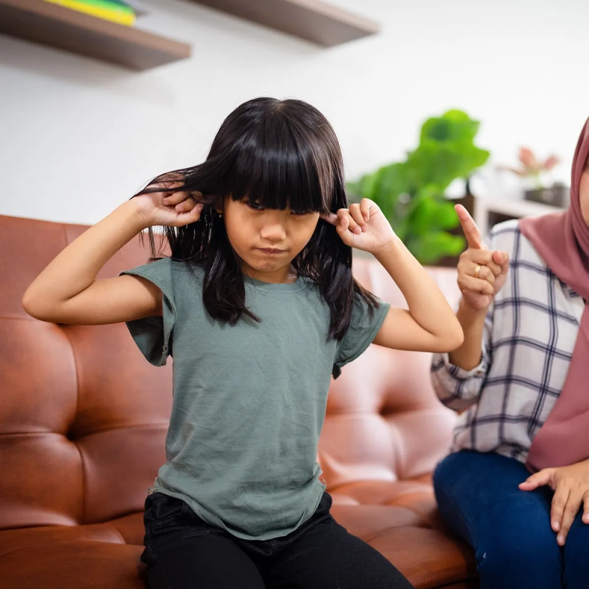 صورة لطفلة تسد آذانها عن سماع لوم أمها