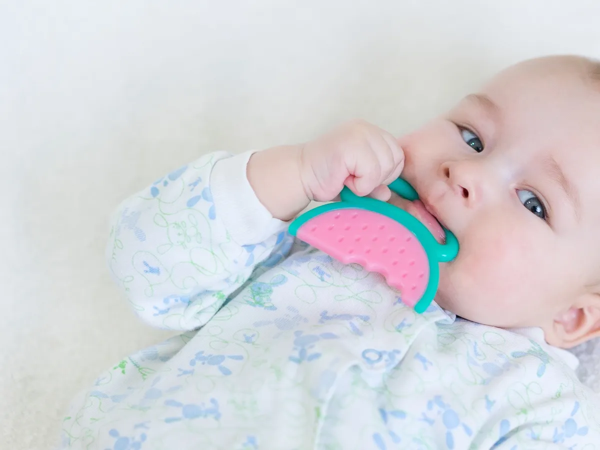 صورة لطفل رضيع يضع لعبة في فمه