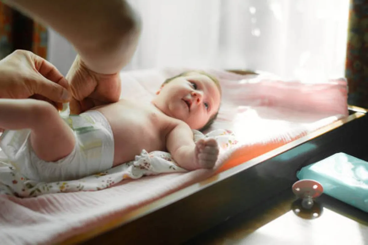 صورة لأم تقوم بتغيير الحفاض بطريقة خاطئة لطفلها