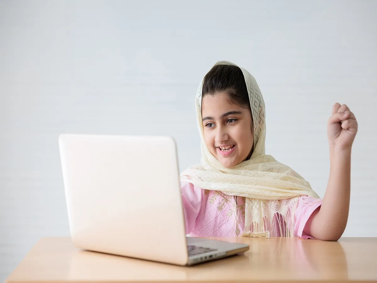 صورة لفتاة تجلس أمام الكمبيوتر