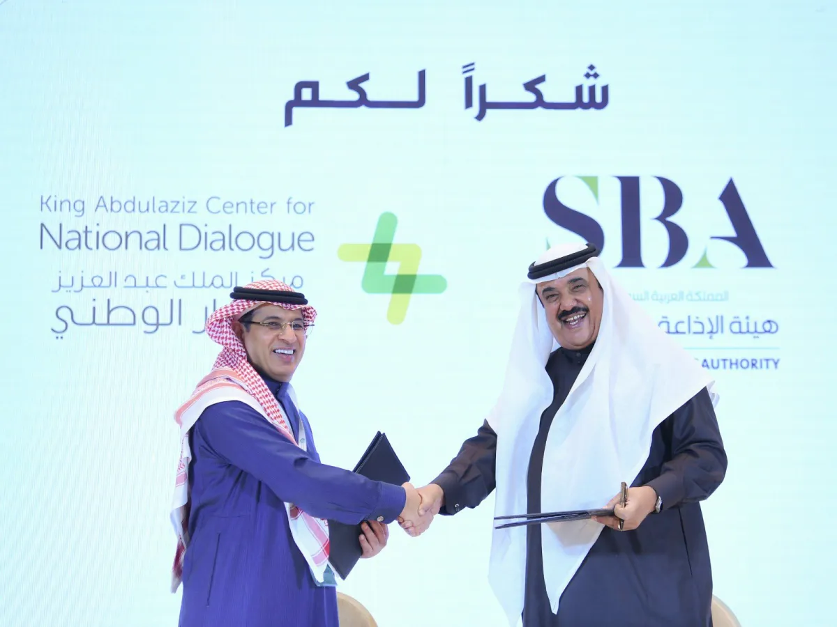 محمد فهد الحارثي وعبدالله الفوزان أثناء توقيع مذكرة التفاهم في المنتدى السعودي للإعلام - الصورة من حساب مركز الحوار الوطني على تويتر