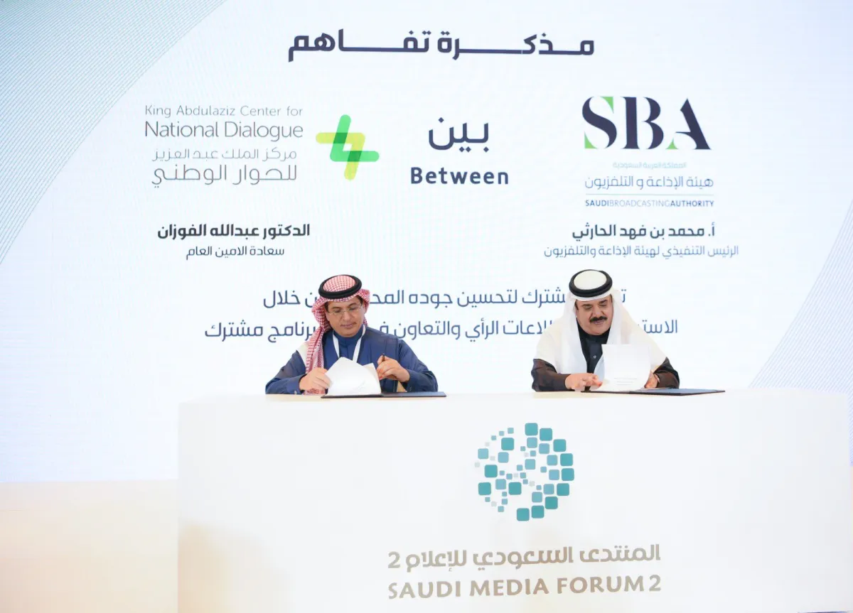 محمد فهد الحارثي وعبدالله الفوزان أثناء توقيع مذكرة التفاهم في المنتدى السعودي للإعلام - الصورة من حساب مركز الحوار الوطني على تويتر