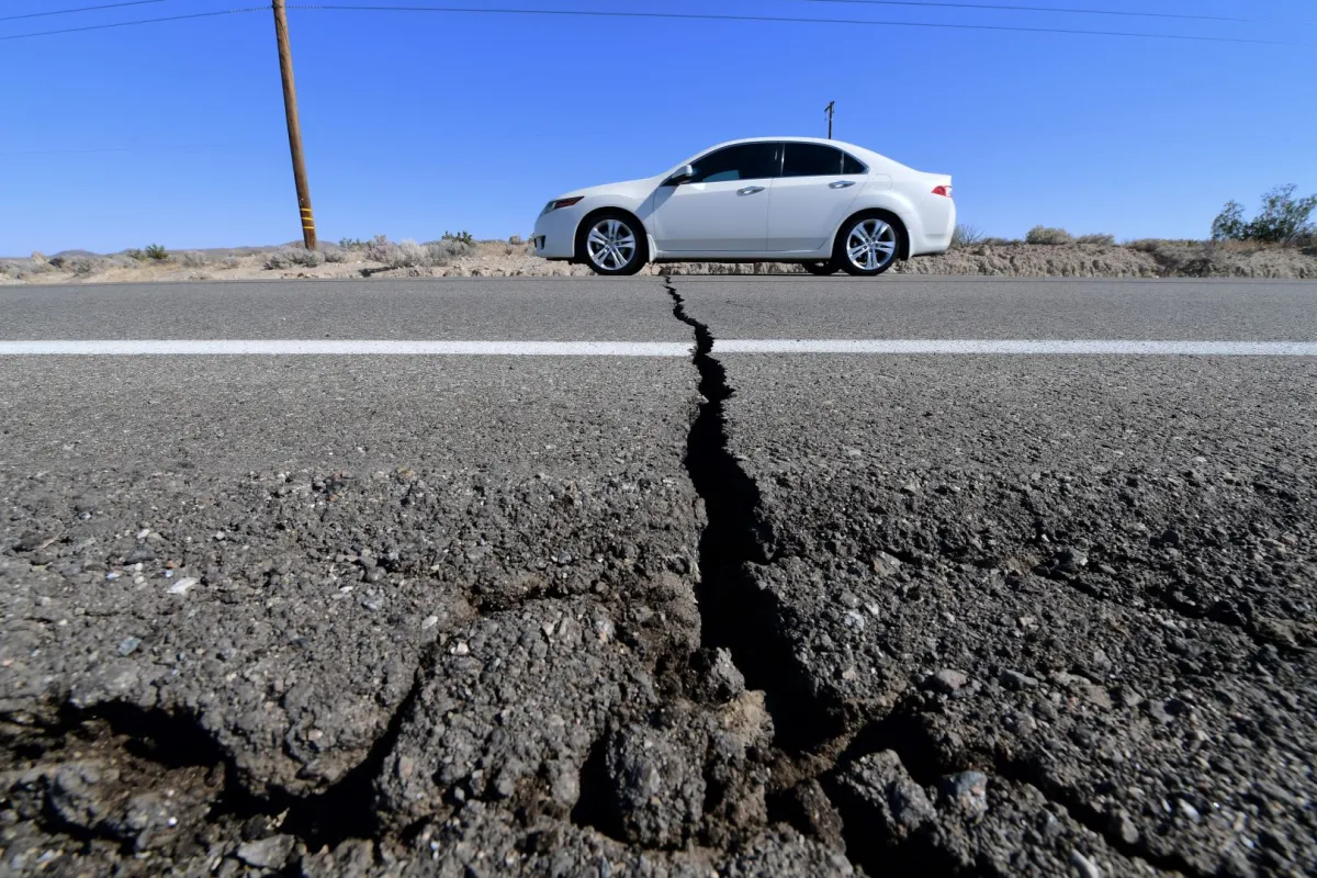 A car drives past a crack in the road on Highway 178, California, on July 4, 2019 FREDERIC J. BROWN / AFP