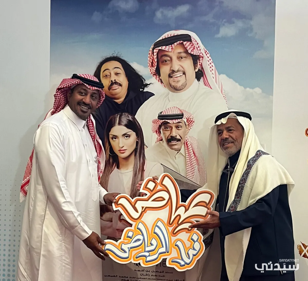 الفنان عبد العزيز المبدل وأحد الحضور أمام بوستر الفيلم