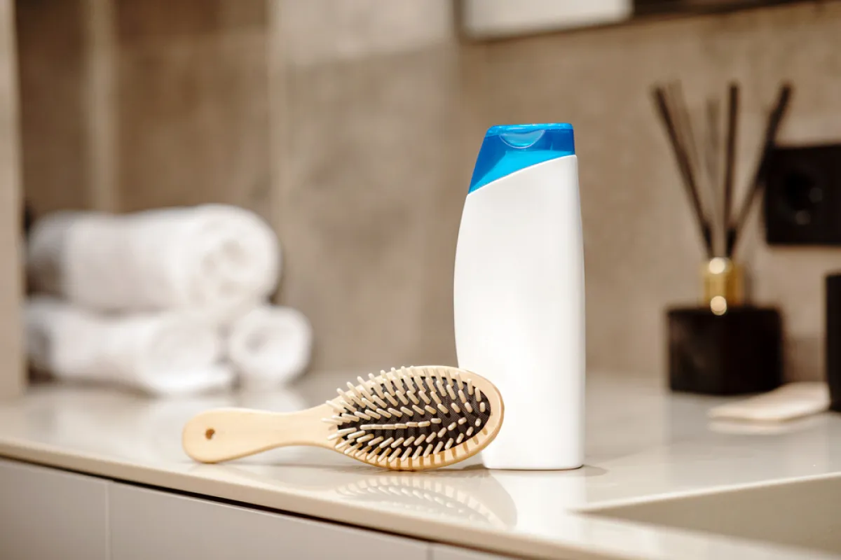 الشامبو والماء الدافئ لتنظيف فرشاة الشعر