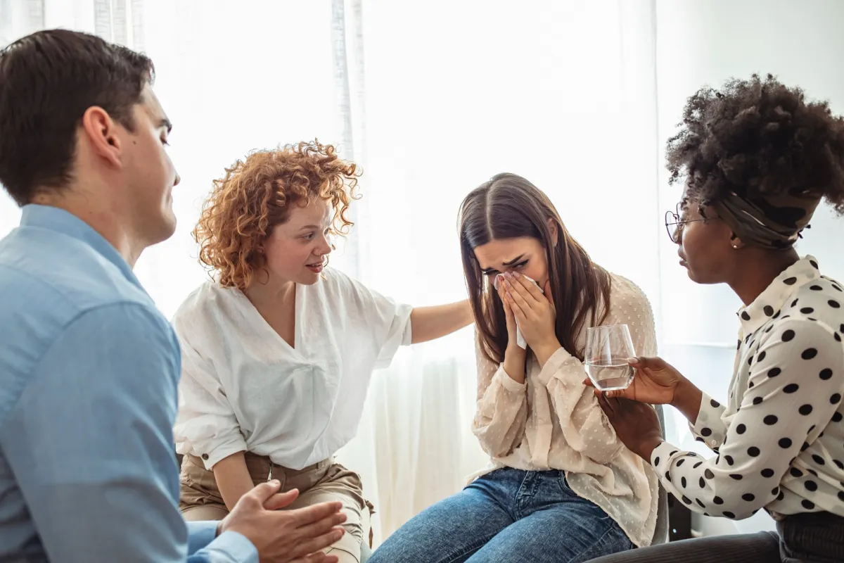 فتاة تبكي أثناء مشاركة مشاعرها مع الآخرين بعد تعرضها لصدمة نفسية (المصدر: Adobe.Stock)