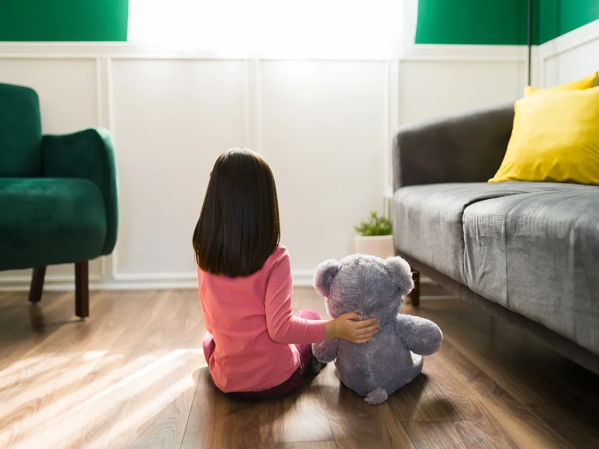 صورة لطفلة تجلس بجانب لعبتها