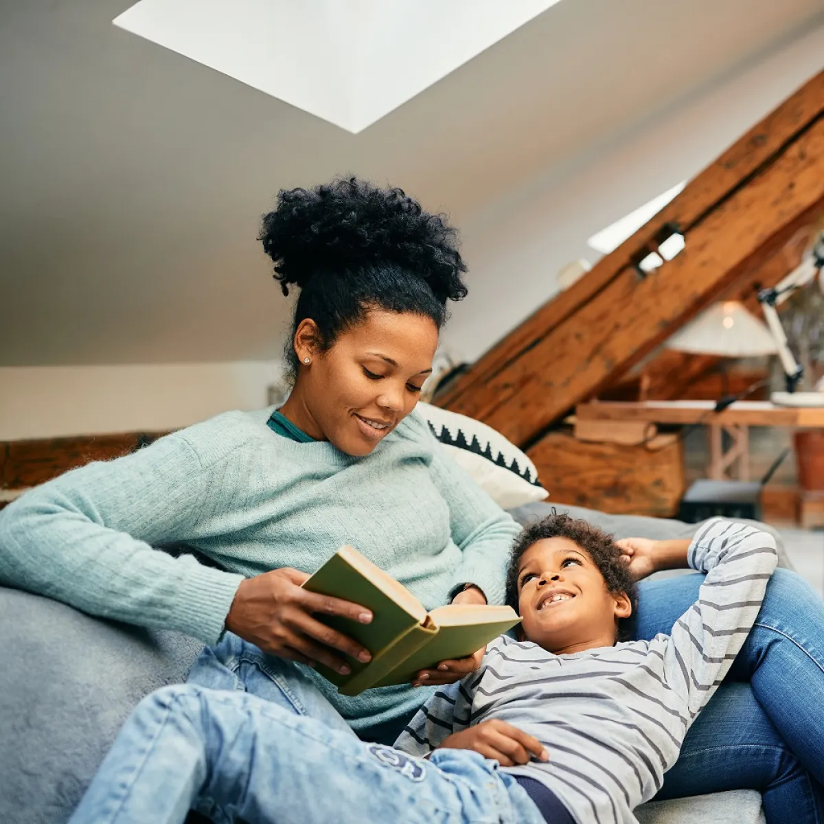 صورة لأم تقرأ لطفلها عن عظمة المرأة